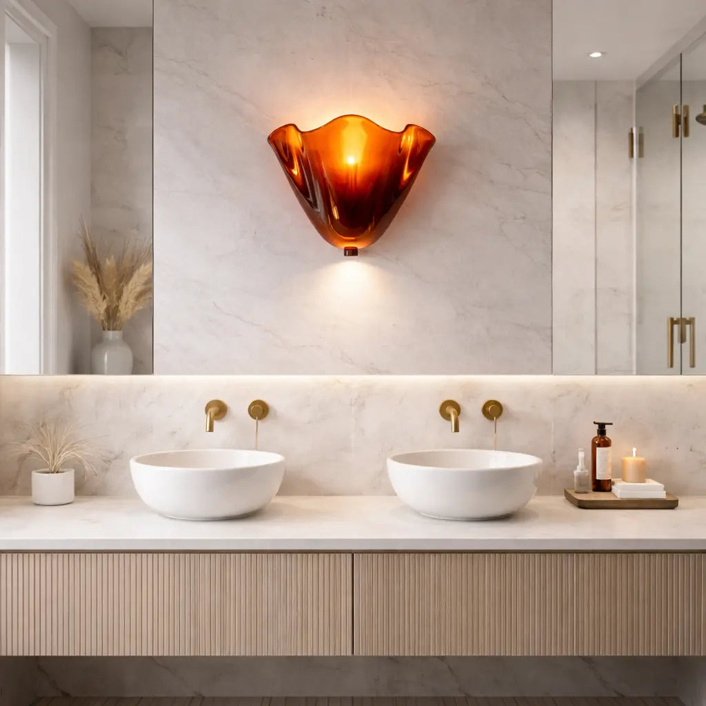 Applique murale en verre rouge ambré installée au mur au-dessus d’un meuble double vasque