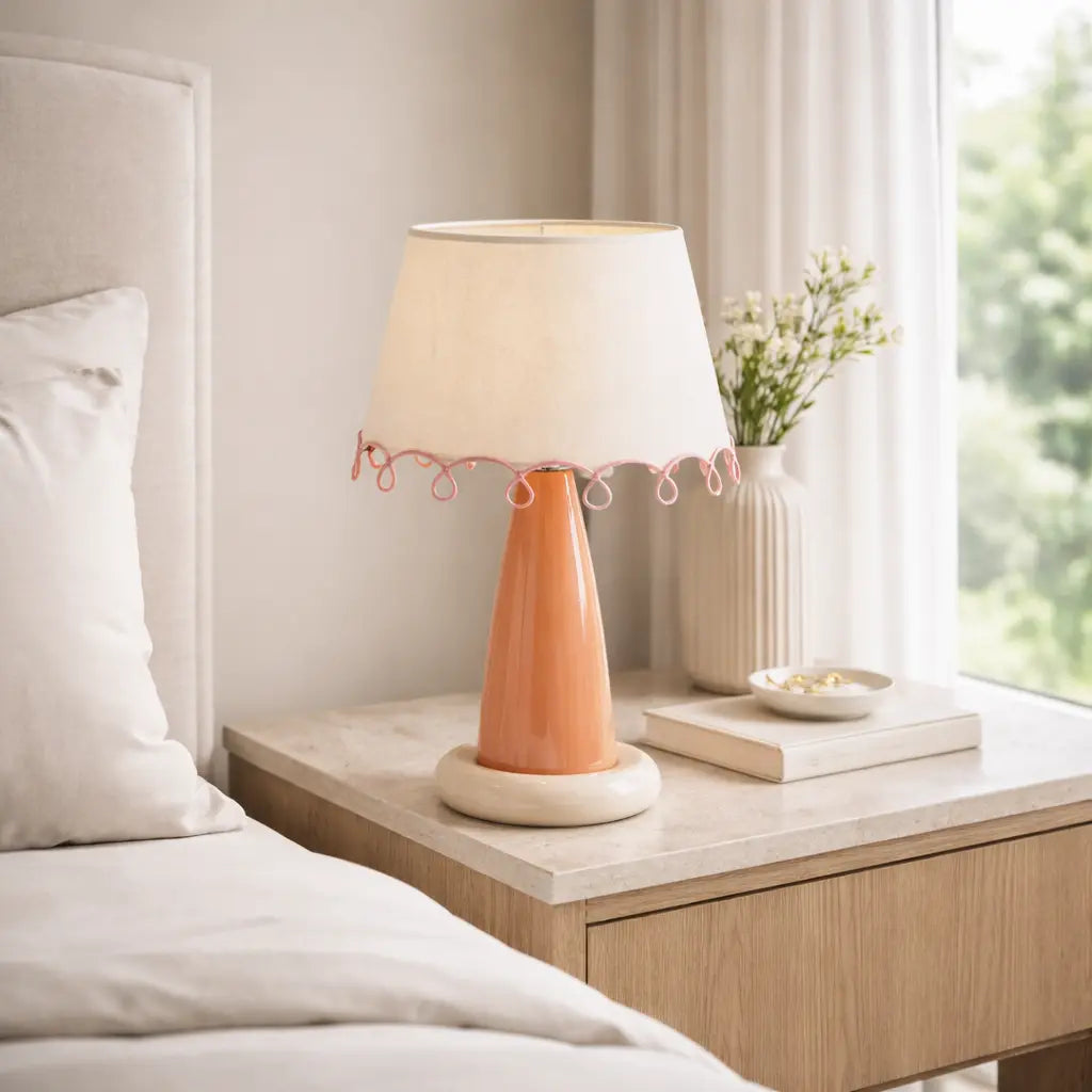 Lampe de table en céramique orange et beige avec abat-jour beige sur table de nuit