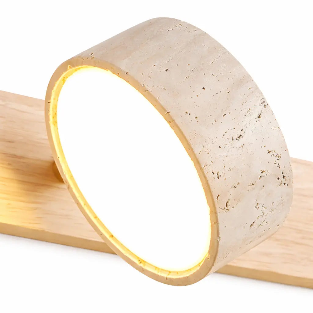 Détail spot LED rond en travertin naturel avec lumière chaude intégrée
